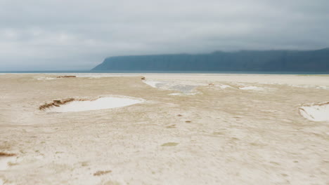 playa desierta con pequeños cráteres en la costa oeste de islandia