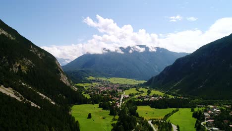 vibrant green fields and distant peaks surround peaceful village, austrian alps