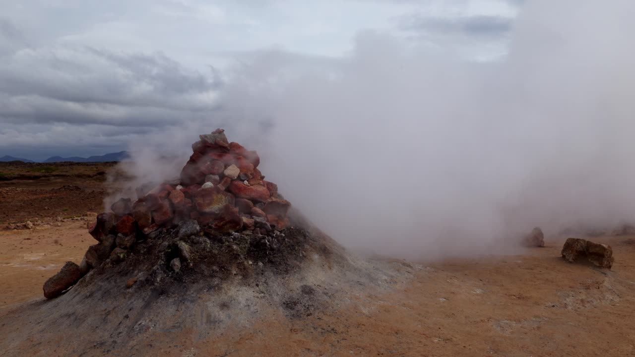 gran fumarola saliendo de las rocas muy rápidamente y sin pausa en la región geotérmica de námaskarð, en islandia