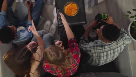 woman switches tv channel to watch game with friends