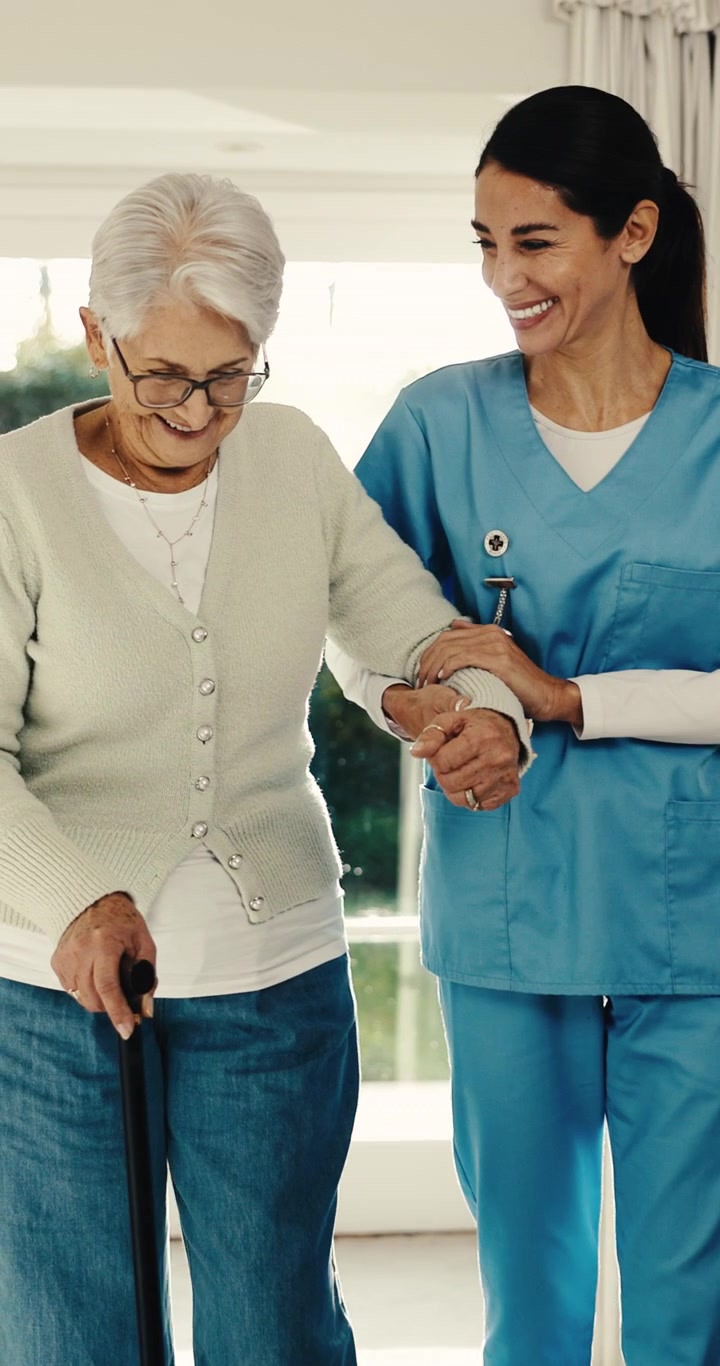 Nurse Assisting Senior Woman Walking with Cane