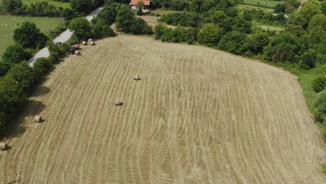 Drone-Sobrevuela-El-Campo-De-Heno-Rural-Después-De-La-Cosecha-De-Verano-Con-Una-Máquina-Agrícola