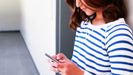 school girl using mobile phone in corridor