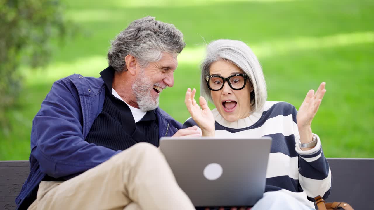 Senior Couple Celebrating Success on Laptop