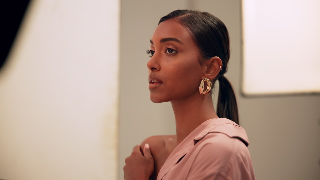Portrait of a woman with earrings and a pink shirt