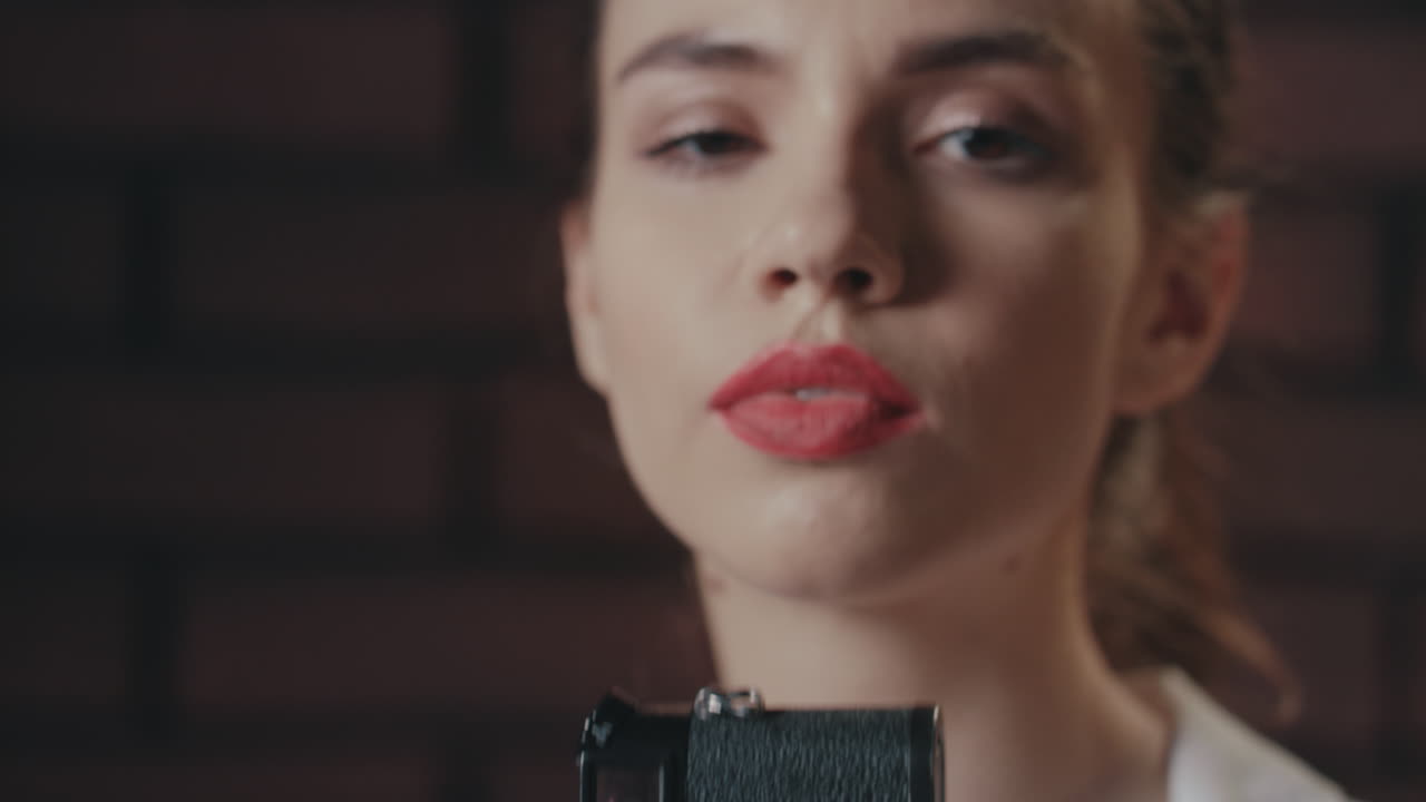 mujer bonita tomando una foto con una cámara de fotos vintage en el fondo de la pared de ladrillo
