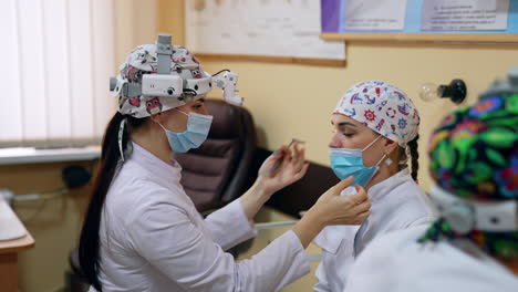 future doctors wearing device glasses check the ent organs of group mates. future otolaryngologists at practical lessons.