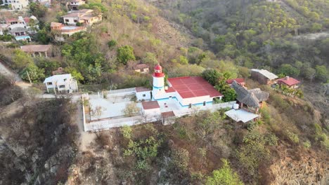 Orbitalflugzeug-Nach-Links-Mit-Klüver-Nach-Oben,-Um-Den-Kleinen-Leuchtturm-Herum,-Mit-Blick-Auf-Die-Klippe-Bei-Sonnenaufgang-An-Der-Küste-Von-Oaxaca