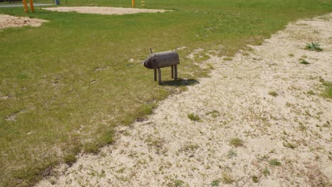 una estatua de cerdo de madera se sienta en un campo en el hotel žnin arche dentro de la antigua fábrica de azúcar en polonia