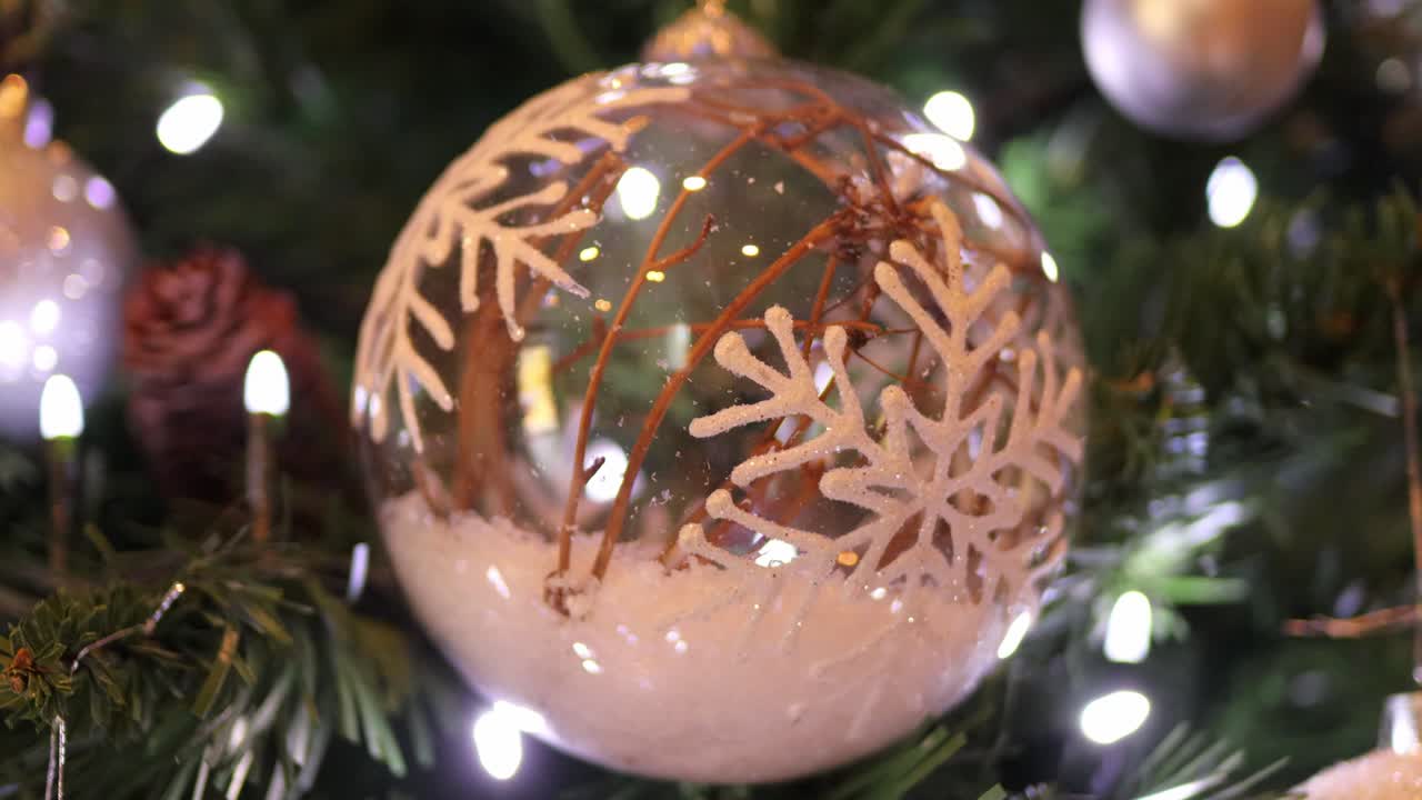 bola de árbol de navidad de vidrio decorada con reflejos de luces y nieve falsa en el interior