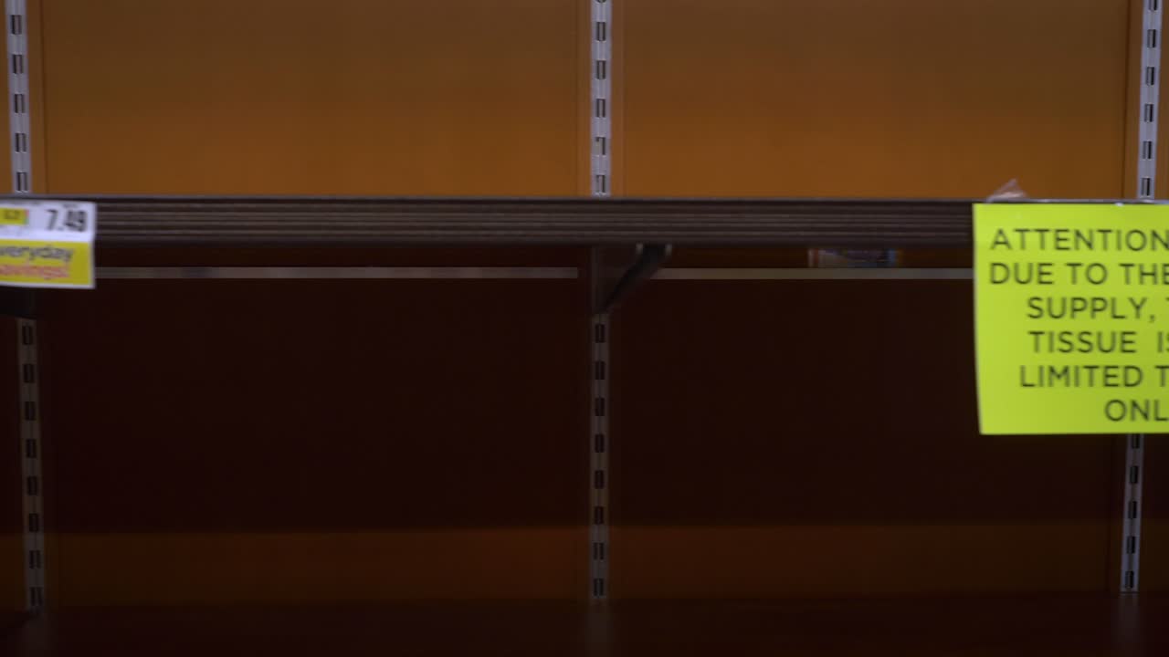 코로나 바이러스 발병 기간 동안 식료품 가게에서 "주의" 표지판이있는 빈 화장실 종이 통로를 걸어가는 4k + 슬라이드