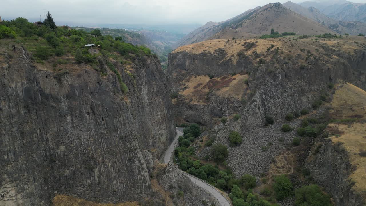aérea desciende en un acantilado cañón de columnas de basalto, los turistas por debajo