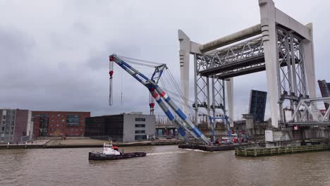 grúa de la industria tirado a través y debajo del puente ferroviario altísimo