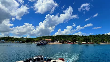 tropical island port with boats docked at the shoreline under bright skies. ideal for travel, tourism, island life, maritime, and coastal culture content
