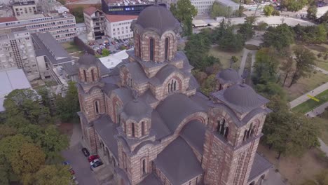 fast dramatic aerial orbiting shot of st mark church in belgrade