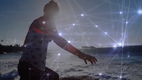 animación de una red de conexiones sobre una mujer practicando yoga en la playa