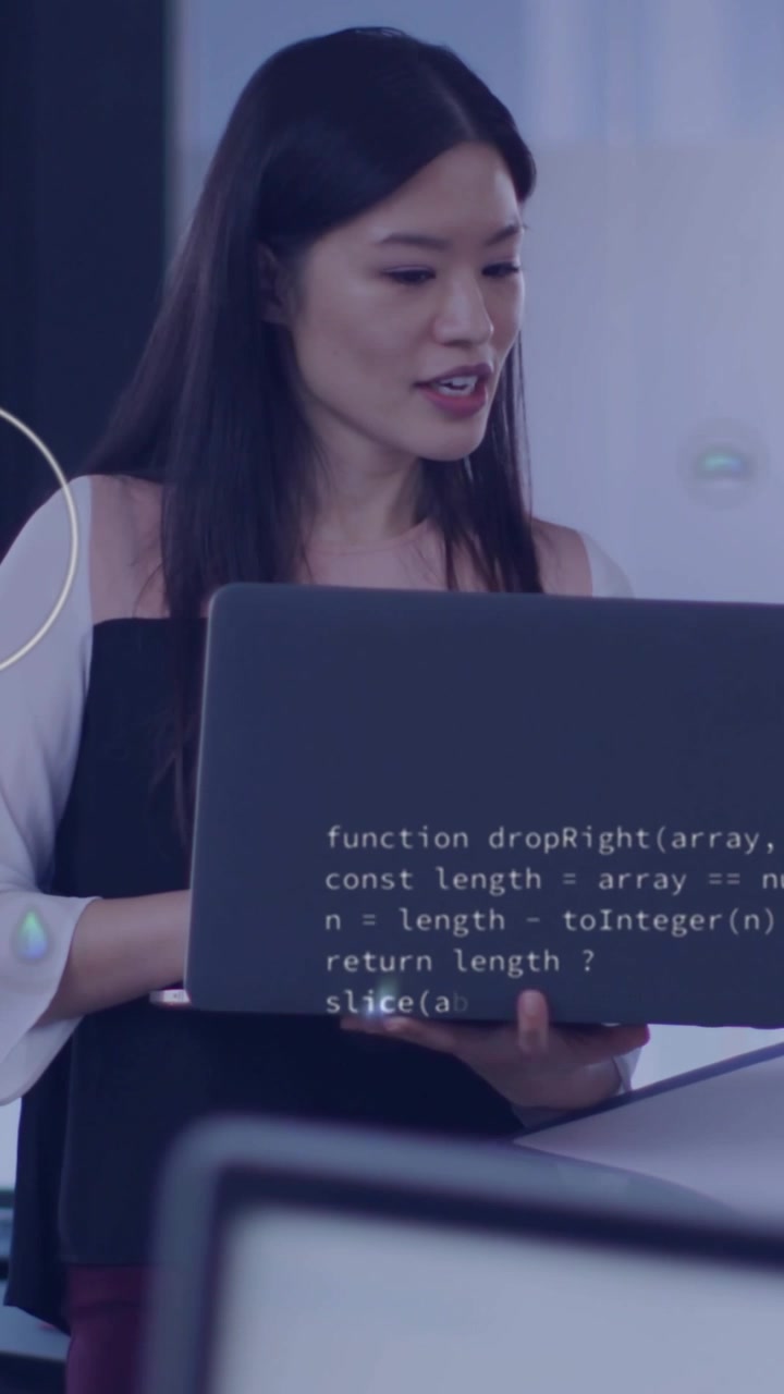 Vertical video: Tech lead turning right and explaining data while holding laptop with AR CO2, code