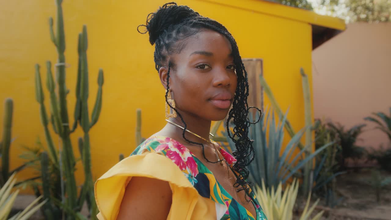 Stylish Black Woman in a Yellow Floral Dress Outdoors