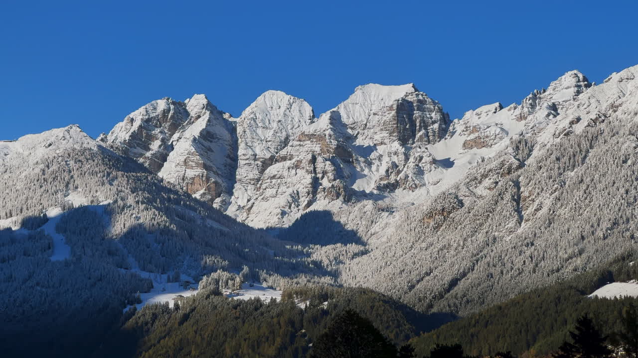 Prima neve di inizio novembre sulle cime delle Alpi europee, austriache e svizzere. Autunno, chalet del villaggio di Stubai, Tirolo, Austria. Sole mattutino ghiacciato, paesaggio montano di Innsbruck. Ripresa statica.
