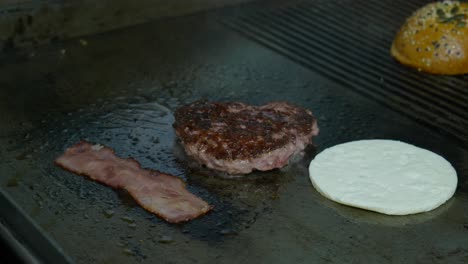 meat, halloumi and bacon for burger on a hot frying pan