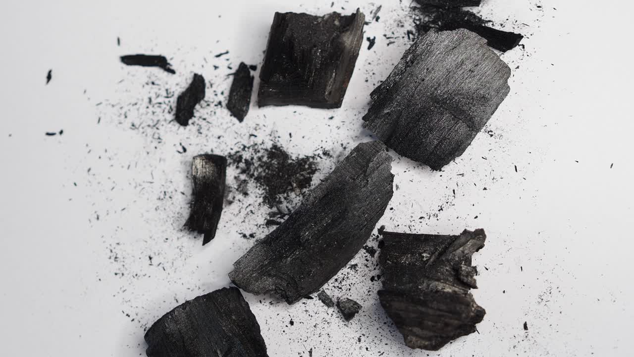 статическое видео угля и грязной пыли, порошка. куча деревянного угля на белом фоне, разрешение 4k