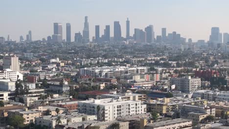 aerial view of cityscape, residential neighborhood and downtown los angeles on a smoggy day
