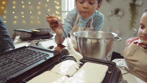 un niño cocinando gofres en la clase de cocina