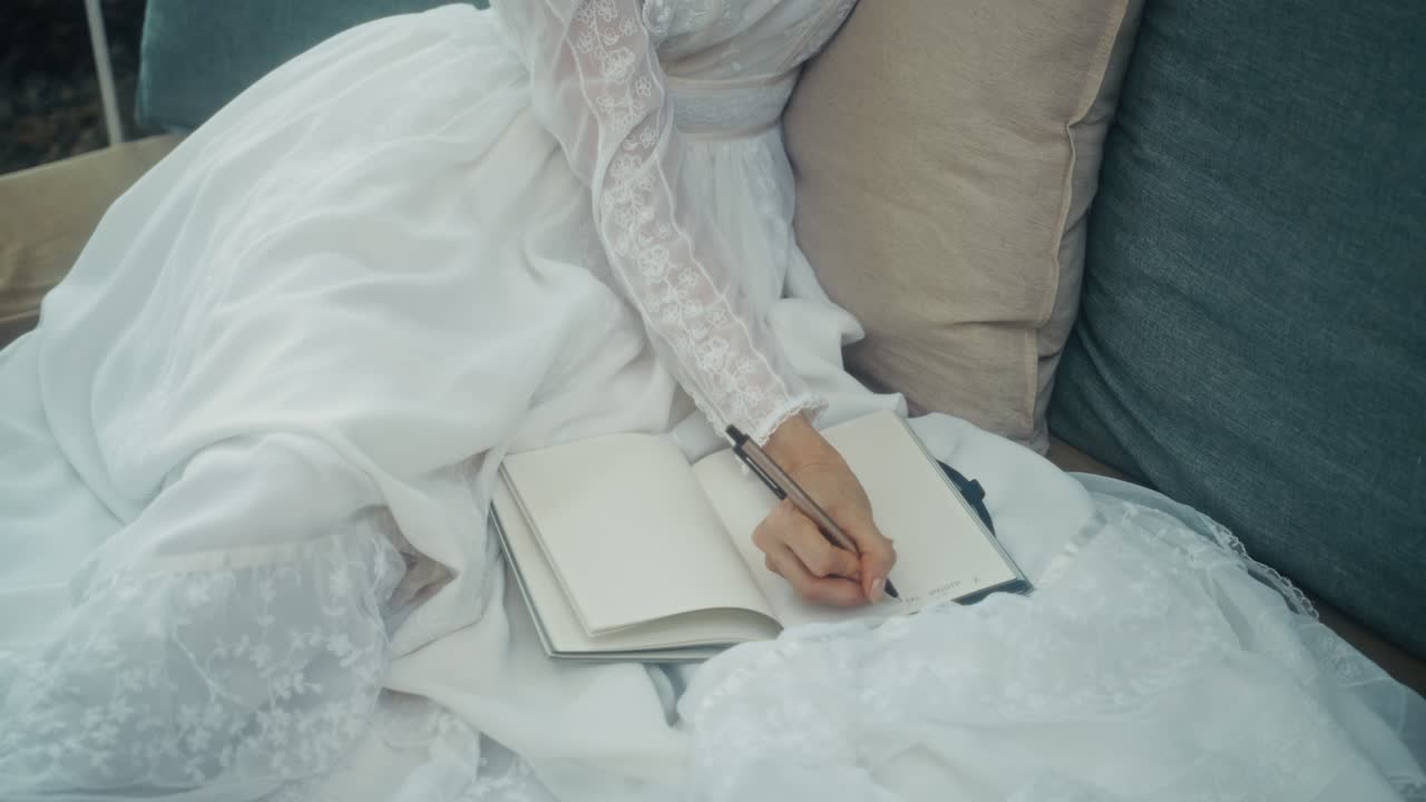 Close-up of Woman's Hand Writing in a Notebook