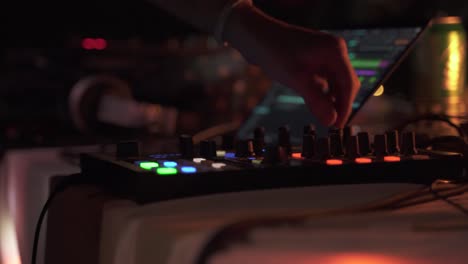 Close-Up-Shot-Of-DJ-Playing-Music-On-Sound-Board-With-Colorful-Lights