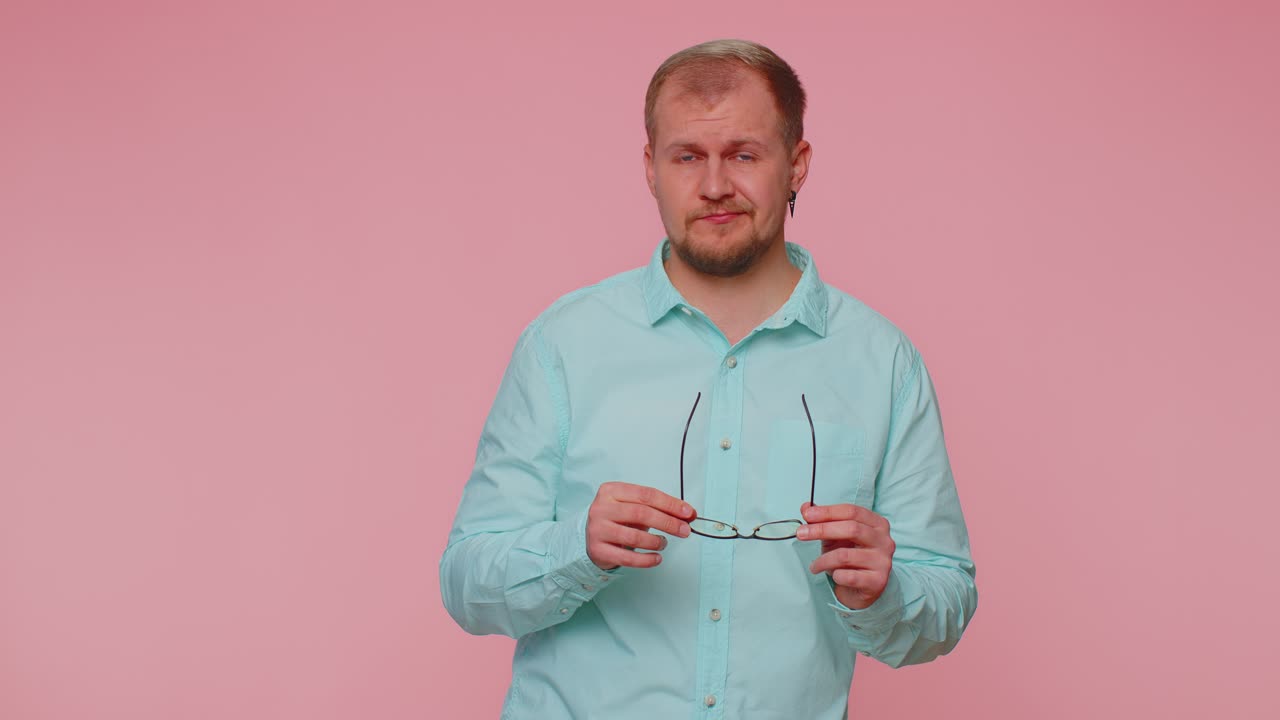 피곤한 남자는 안경을 벗고 눈에 통증이 느지고, 과로, 긴 시간의 스트레스로 인해 피곤합니다.