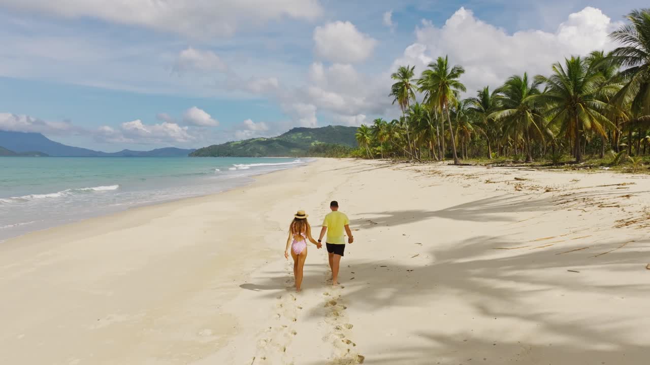 Filmagem com drone de um casal caminhando na praia de Nagtulay, Palawan, Filipinas