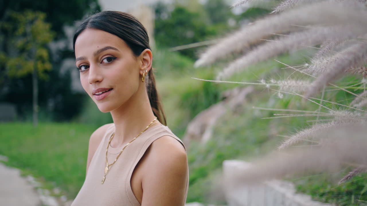 chica soñadora posando cámara en el jardín retrato vertical. mujer romántica sonriendo