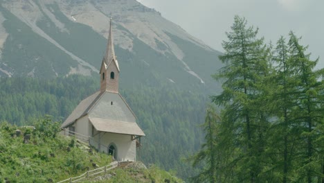 close up shot, scenic view of a church on the top of the hill in italy, reschensee behind the camera