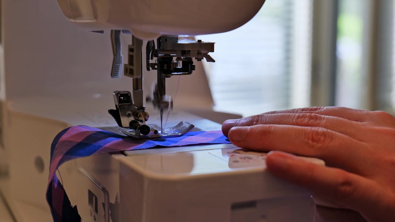 Tailor Stitching Cloth Fabric on Electric Sewing Machine. Close Up View