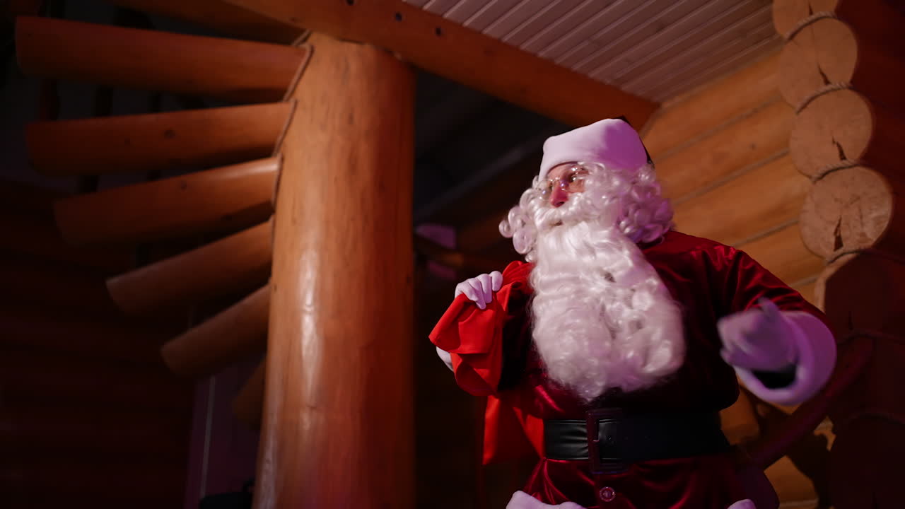 Santa Claus coming into the house quietly. Authentic Santa with white beard and red costume carrying presents to children at New Year's night.