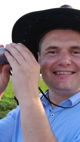 surprised look of a young agronomist looking through binoculars at field surprised look of a young agronomist looking through binoculars at a soybean field
