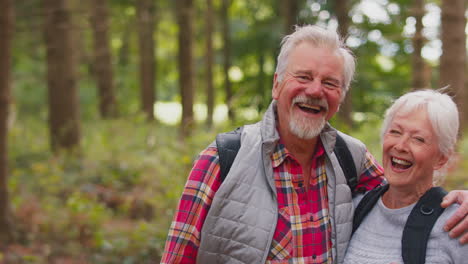 portrait of loving retired senior couple walking in woodland countryside together