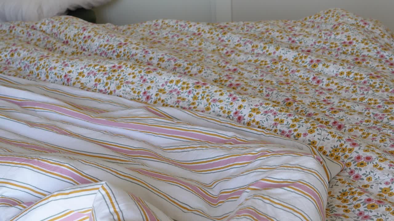 Bed with floral and striped bedding