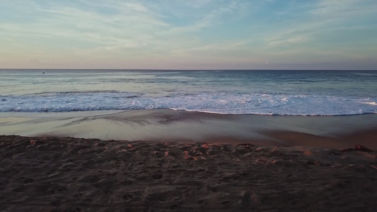 Aerial drone wide angle of flying over calm ocean waves at beach at day