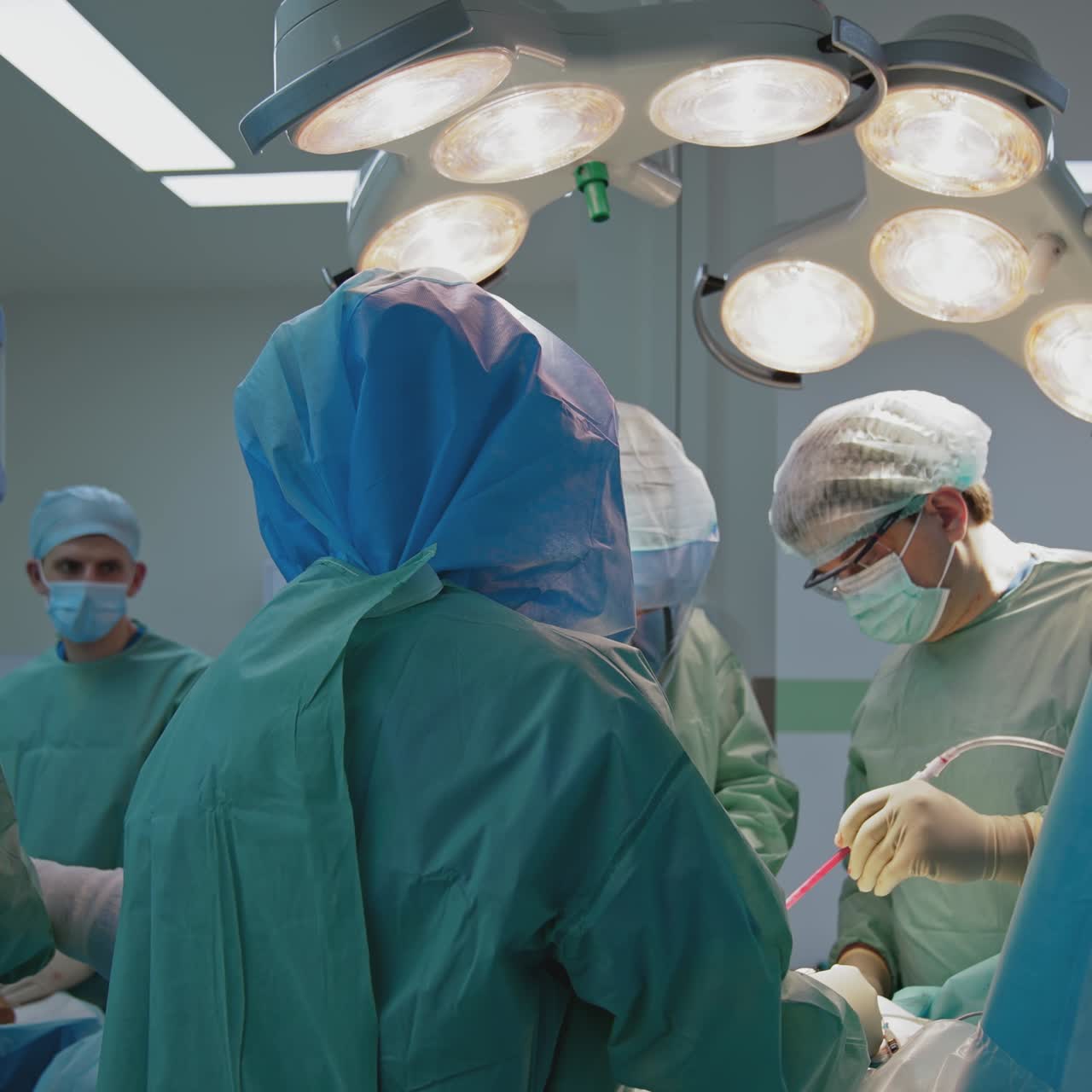 Operating room with surgery in progress. Medical team performing surgical operation in bright modern operating room