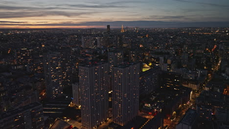 Una-Toma-Aérea-Nocturna-Que-Muestra-La-Expansión-Urbana-De-Las-Olimpiadas-Y-Destellos-Del-Sena.