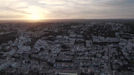 praia da luz sprawling townscape in algarve landscape at sunset. aerial