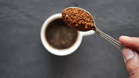 adding instant coffee to a cup