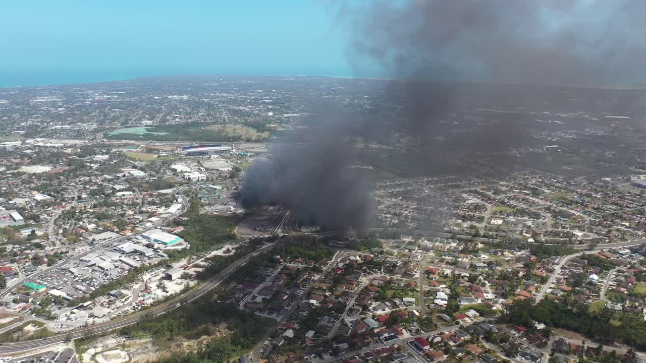 Fire and Smoke in Nassau, Bahamas. Drone Aerial Of Burning Building Near Football Stadium