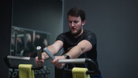 Bearded-caucasian-male-do-back-exercise-on-leverage-low-row-machine-at-gym