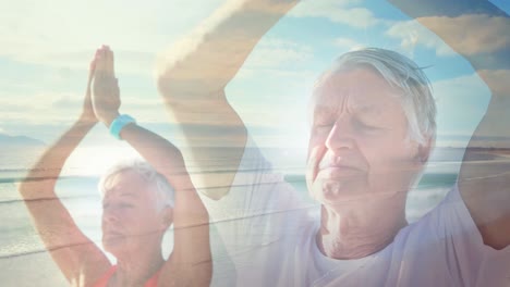 animation of glowing light over senior couple practicing yoga by seaside