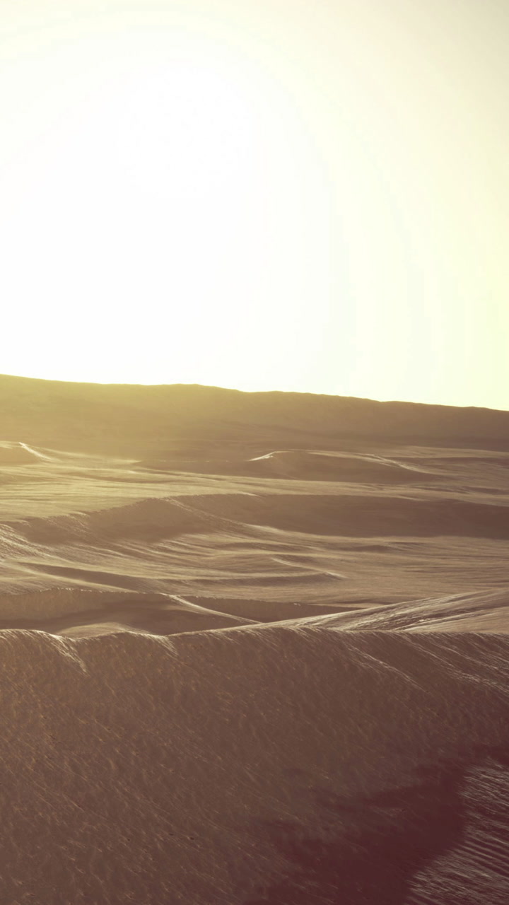 Expansive desert landscape under soft golden sunlight at dusk