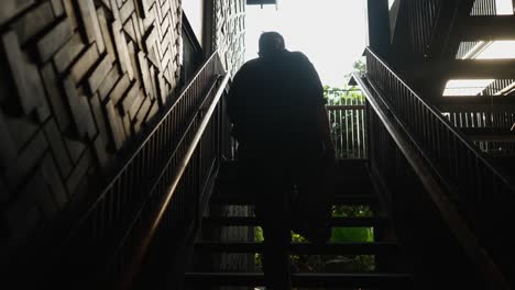 silhouetted person ascending stairs