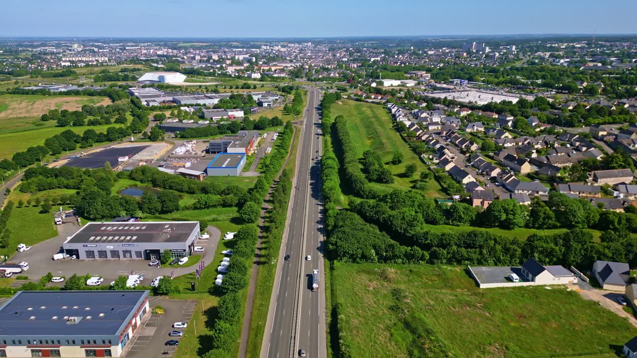 Laval suburbs, road, houses, industrial area, and green spaces on outskirts of Laval, Mayenne, France, urban planning, residential. Aerial forward