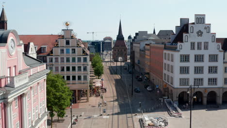 Forwards-fly-above-street-with-tram-tracks-leading-through-historic-city-centre.-Street-ended-with-Steintor-town-gate